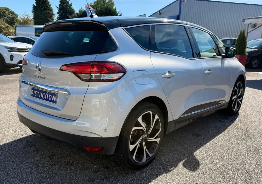Vue 3/4 arrière droite d'un Renault Scénic IV gris platine avec toit noir étoile et jantes distinctives.