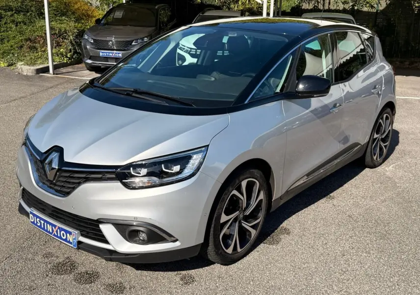 Renault Scénic IV gris platine avec toit noir, vue 3/4 avant droit mettant en valeur ses jantes distinctives.
