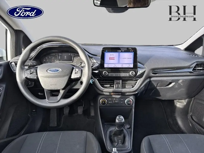 Vue intérieure frontale du tableau de bord et volant de la Ford Fiesta 1.1 75ch Cool & Connect avec écran tactile et boîte manuelle.