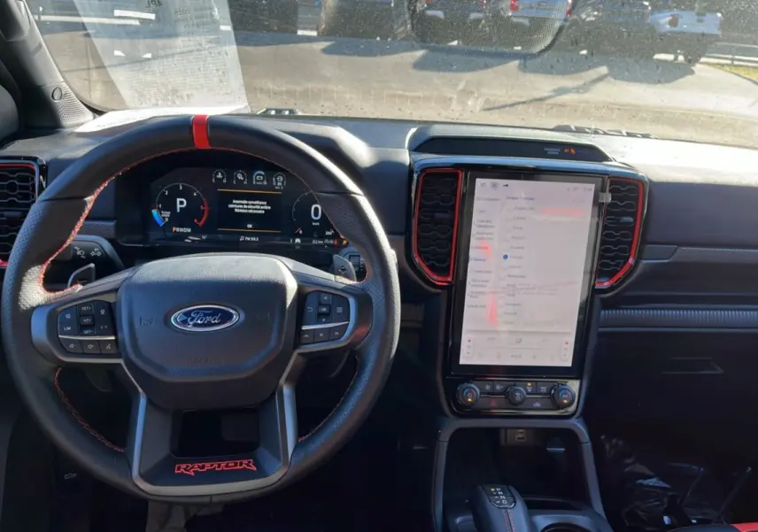 Vue intérieure du tableau de bord du Ford Ranger Raptor 2025, avec volant cuir noir et écran tactile vertical.