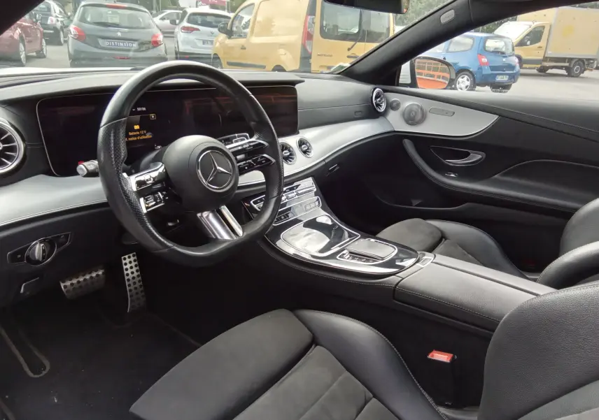 Intérieur noir de la Mercedes Classe E Coupé 220D AMG Line 2020, vue côté conducteur avec tableau de bord et volant visibles.