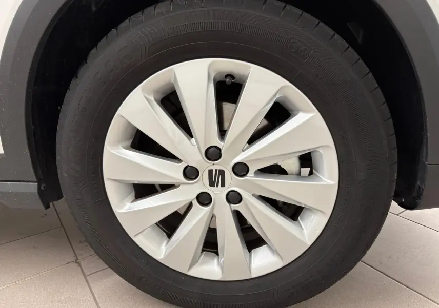 Gros plan sur la roue avant gauche du SEAT Arona blanc avec jante argentée et pneu Goodyear.