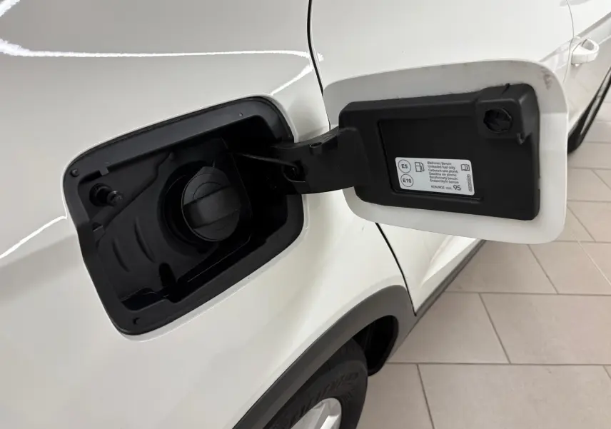 Vue rapprochée du bouchon de carburant ouvert côté gauche d'un SEAT Arona blanc avec toit noir.
