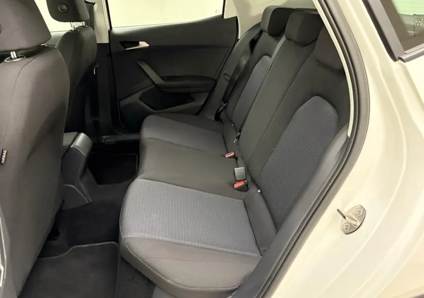 Vue intérieure côté droit des sièges arrière noirs du SEAT Arona 2023 avec portière blanche ouverte.