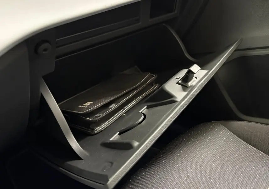 Gant de boîte à gants ouvert avec manuel SEAT visible, intérieur noir du SEAT Arona 2023 côté passager.