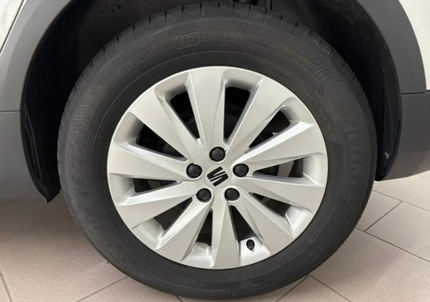 Gros plan sur la roue avant gauche d'une SEAT Arona 2023 blanche avec jante alliage et logo central noir.