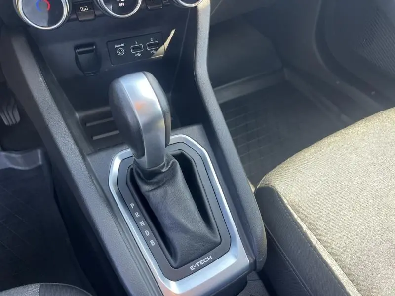 Le levier de boîte automatique noir et argenté de la Renault Clio 1.6 E-Tech vu en gros plan côté console centrale.