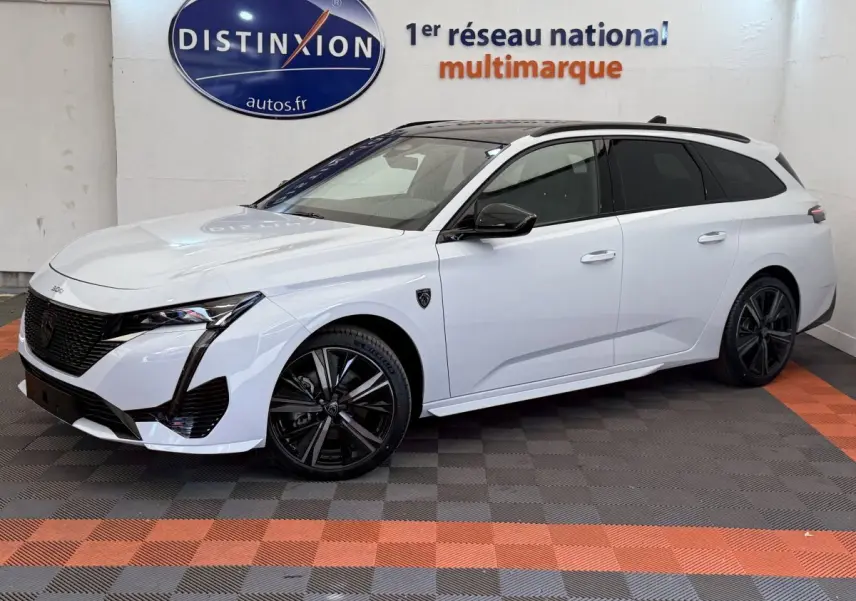 Peugeot 308 Hybrid 136 e-DCS6 GT blanche vue de 3/4 avant droit avec jantes noires et toit noir.