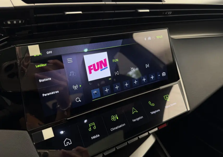 Écran tactile central de la Peugeot 308 Hybrid GT 2024 affichant la radio Fun, vue intérieure côté passager.