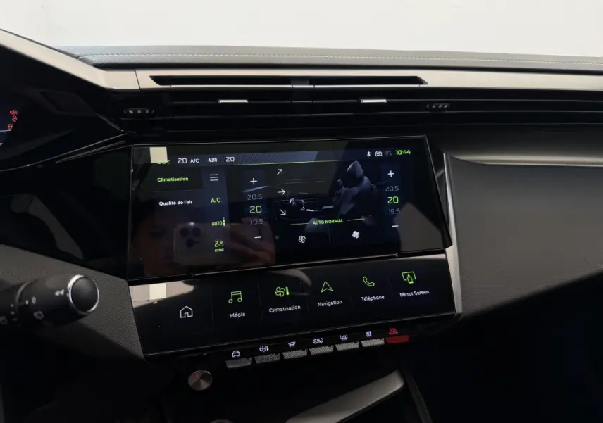 Tableau de bord central tactile de la Peugeot 308 Hybrid 136 e-DCS6 GT 2024, affichage climatisation et multimédia.