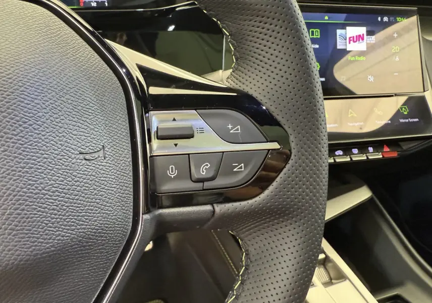 Gros plan sur le volant cuir perforé et les commandes multifonctions du Peugeot 308 Hybrid 136 e-DCS6 GT 2024.