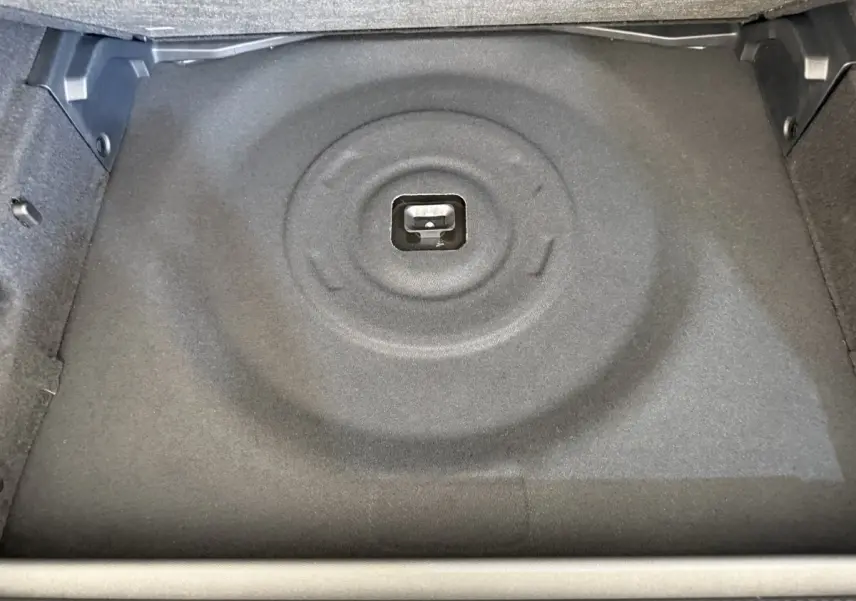 Coffre de Peugeot 308 Hybrid 136 e-DCS6 GT 2024, vue plongeante sur le rangement sous plancher gris foncé.