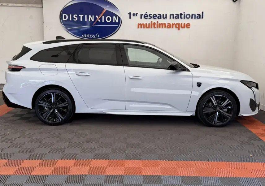Profil droit d'une Peugeot 308 Hybrid 136 e-DCS6 GT blanche, avec jantes noires et toit ouvrant panoramique.