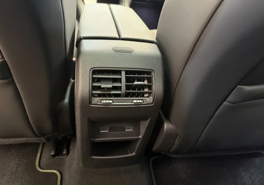 Vue rapprochée des aérateurs arrière et ports USB entre les sièges noirs de la Peugeot 308 Hybrid 136 e-DCS6 GT 2024.