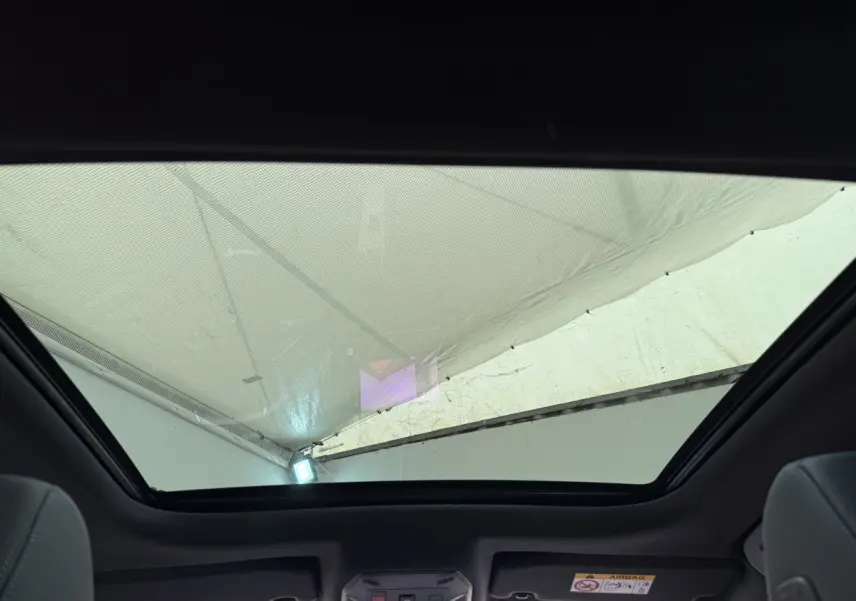 Toit panoramique ouvert vu de l'intérieur arrière d'une Peugeot 308 Hybrid 136 e-DCS6 GT blanche, 2024