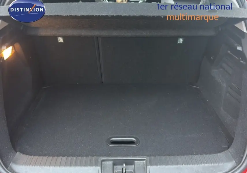 Coffre ouvert vu de face du Renault Captur rouge flamme, montrant un espace de chargement propre et vide.