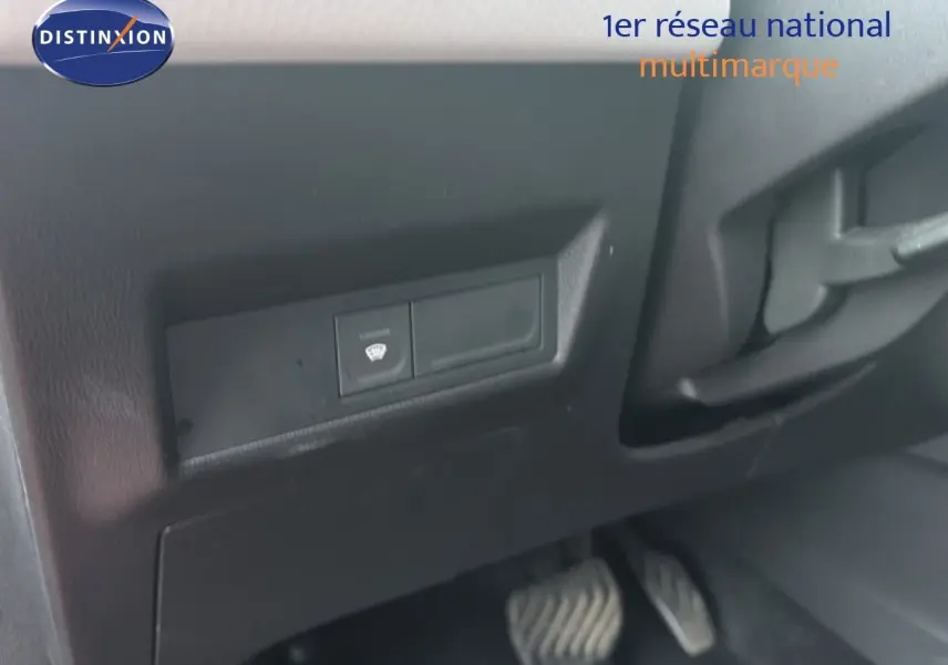 Détail intérieur montrant le bouton de dégivrage et les pédales côté conducteur d’un Renault Captur rouge flamme 2020.