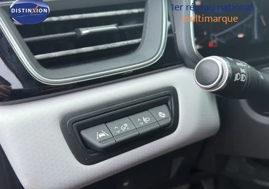 Gros plan sur les commandes d'assistance à la conduite dans l'habitacle du Renault Captur rouge flamme, côté gauche.