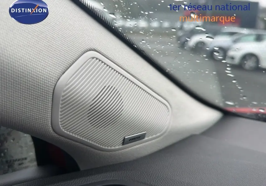 Haut-parleur Bose intégré côté gauche du tableau de bord d’un Renault Captur Rouge Flamme, vue intérieure rapprochée.