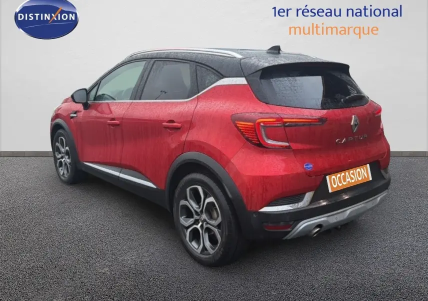 Vue 3/4 arrière droite du Renault Captur rouge flamme avec toit noir et jantes alliage bicolores.
