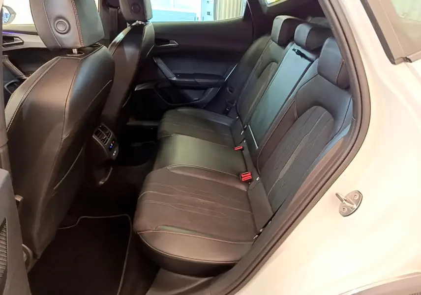 Vue intérieure côté droit des sièges arrière noirs en cuir et tissu du CUPRA Formentor 2023 avec surpiqûres rouges.