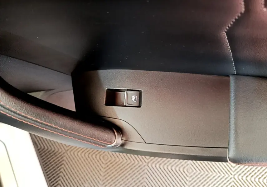 Détail intérieur du levier de frein à main en cuir noir avec surpiqûres rouges du CUPRA Formentor 2023.