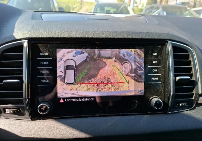 Vue intérieure de la porte avant gauche d’un Skoda Karoq gris, avec poignée et commandes de vitres.