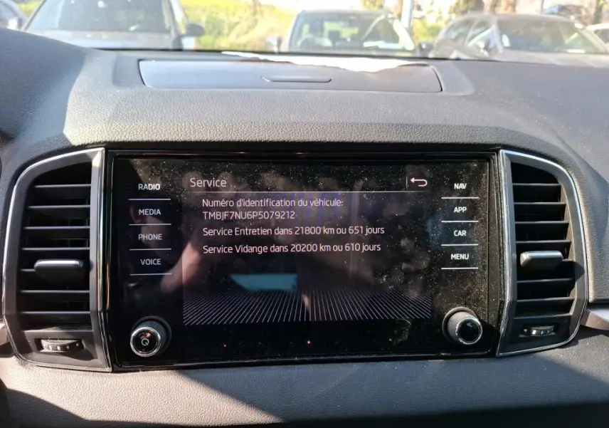 Détail intérieur de la porte avant gauche du Skoda Karoq gris, avec commandes de vitres et poignée chromée.