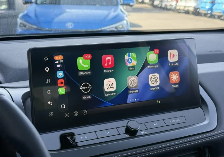 Vue intérieure du tableau de bord du Nissan Qashqai 2025 avec écran tactile large affichant Apple CarPlay.