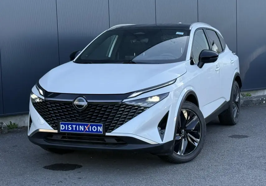 Nissan Qashqai blanc nacré en 3/4 avant droit, avec calandre noire et jantes alliage 19 pouces.