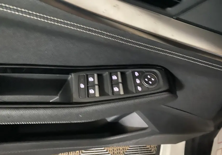 Commande des vitres et rétroviseurs sur la porte côté gauche d'un Renault Austral blanc nacré 2023 E-Tech 200 Techno.