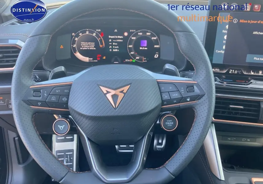 Vue frontale du volant sport en cuir perforé noir avec logo CUPRA et tableau de bord numérique lumineux.