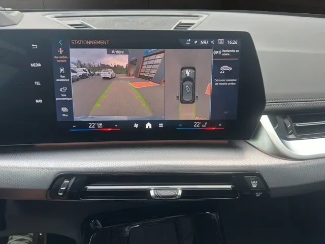 Écran central du BMW X1 2024 montrant l'aide au stationnement avec vue arrière et caméra 360 degrés.