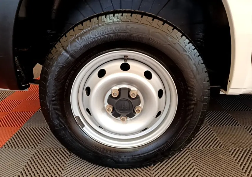 Gros plan sur la roue avant droite blanche du Fiat Ducato Fourgon 2021 avec jante acier et logo FIAT central.