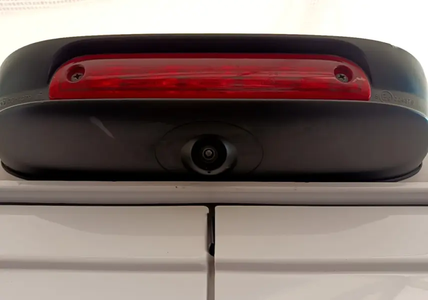 Gros plan sur la caméra de recul et le feu stop supérieur du Fiat Ducato Fourgon blanc, vue arrière haute.