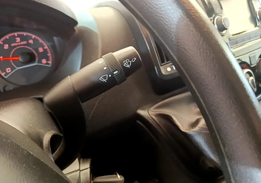 Gros plan sur la commande d’essuie-glace à gauche du volant dans l’habitacle du Fiat Ducato Fourgon blanc.