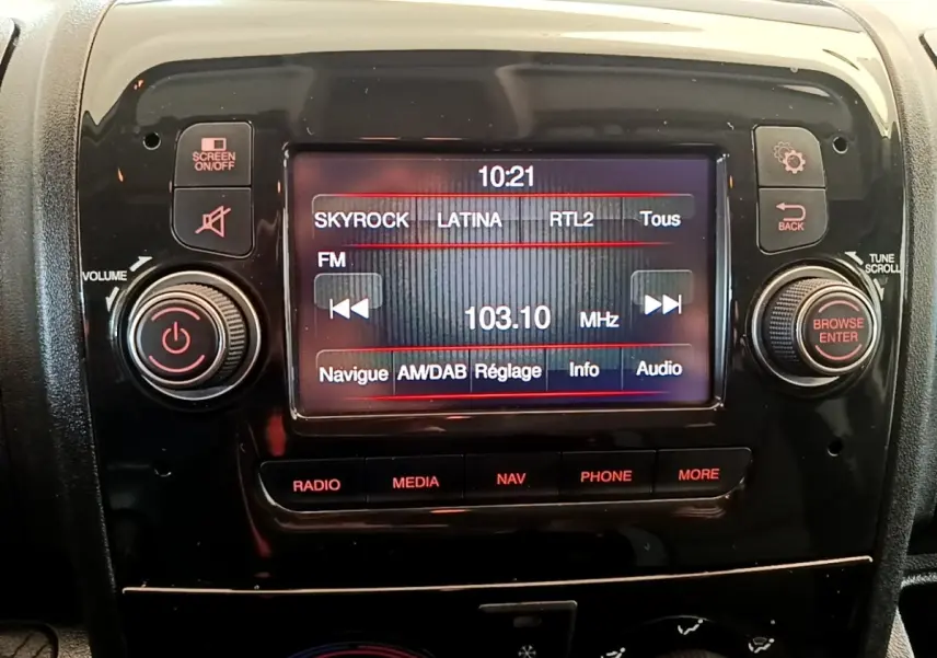 Gros plan sur l’écran tactile multimédia noir du tableau de bord du Fiat Ducato Fourgon blanc, affichant une radio FM.