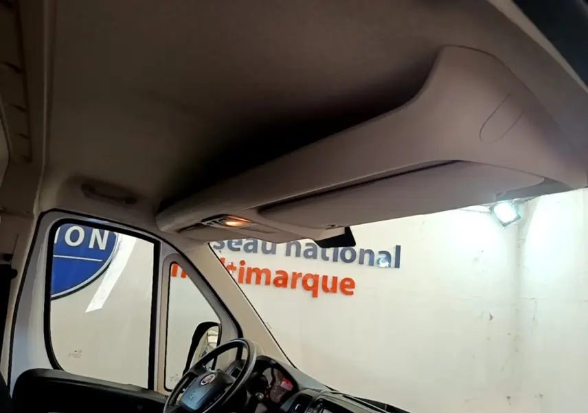 Vue intérieure du Fiat Ducato Fourgon blanc 2021, angle avant gauche, volant multifonctions et tableau de bord tactile visibles.