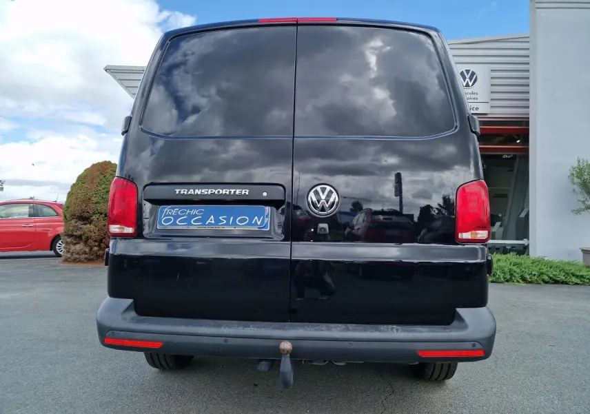 Vue arrière d'un Volkswagen Transporter noir 2020 avec attelage rigide et feux arrière rouges visibles.
