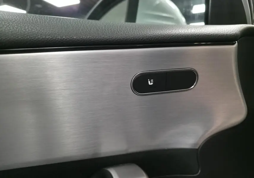 Détail du bouton de siège chauffant sur la garniture intérieure argent brossé d'une Mercedes Classe A AMG Line 2019.