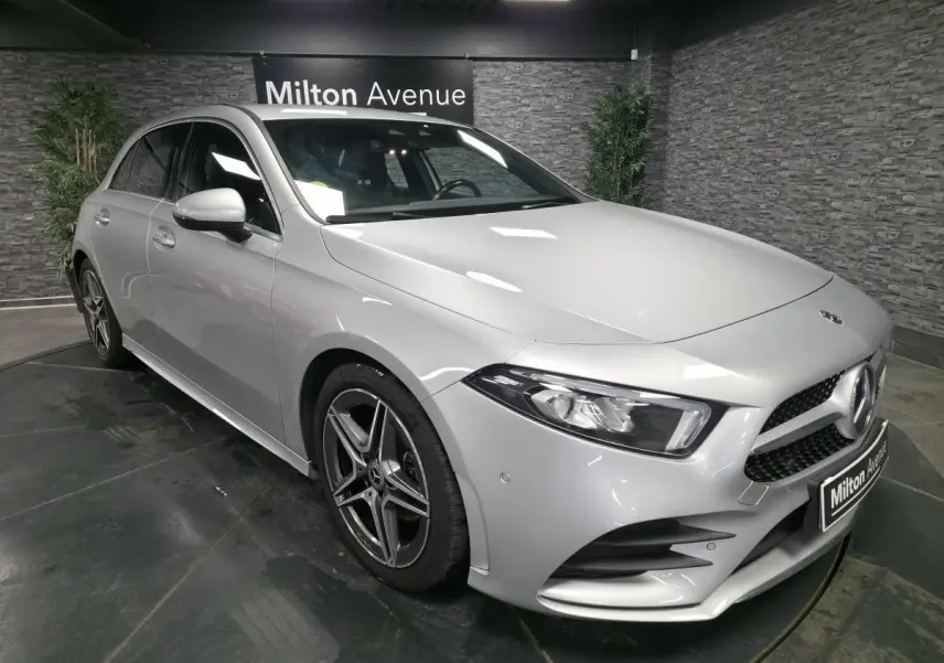 Vue 3/4 avant droite d'une Mercedes Classe A gris métallisé avec jantes AMG et calandre diamantée.