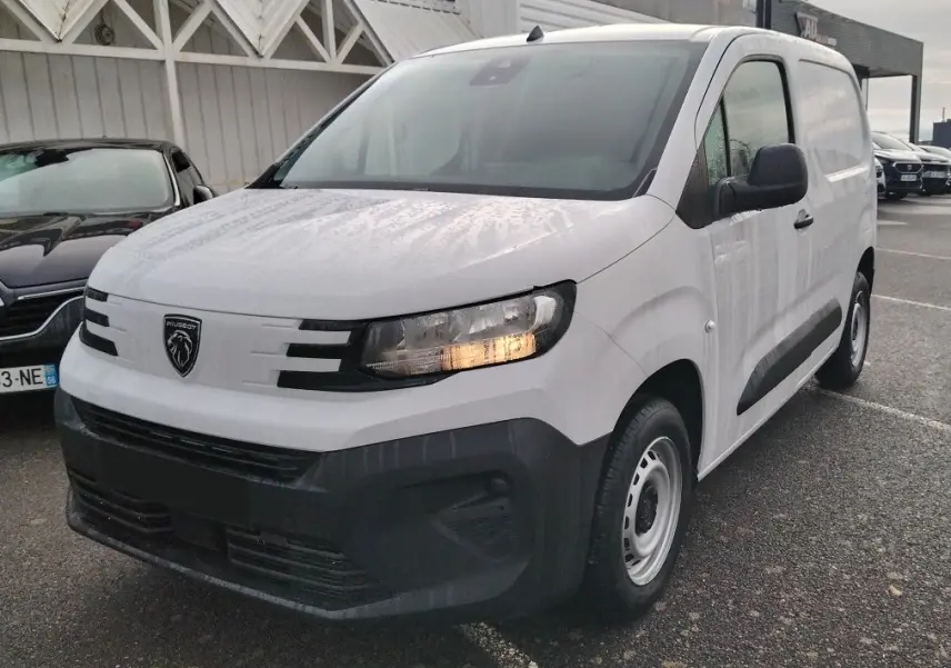 Peugeot Partner Fourgon blanc Icy vu en 3/4 avant droit, avec calandre noire et feux allumés.