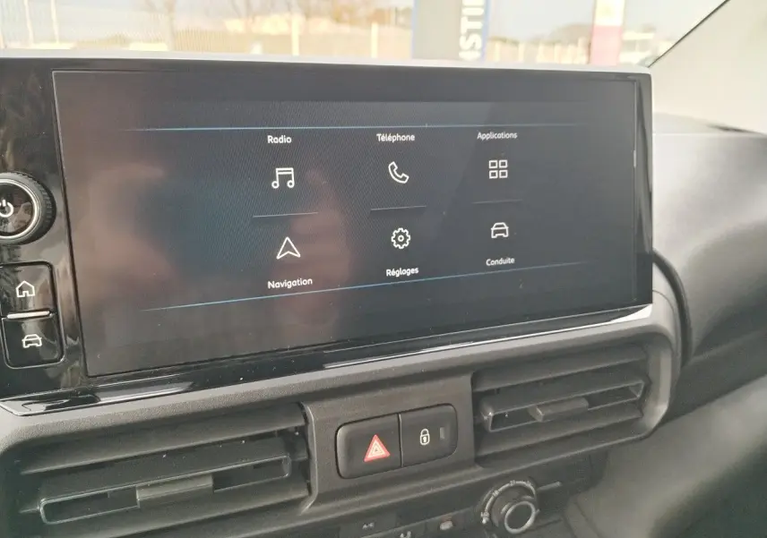 Écran tactile central du Peugeot Partner Fourgon blanc Icy 2025, affichant les menus radio, téléphone et navigation.