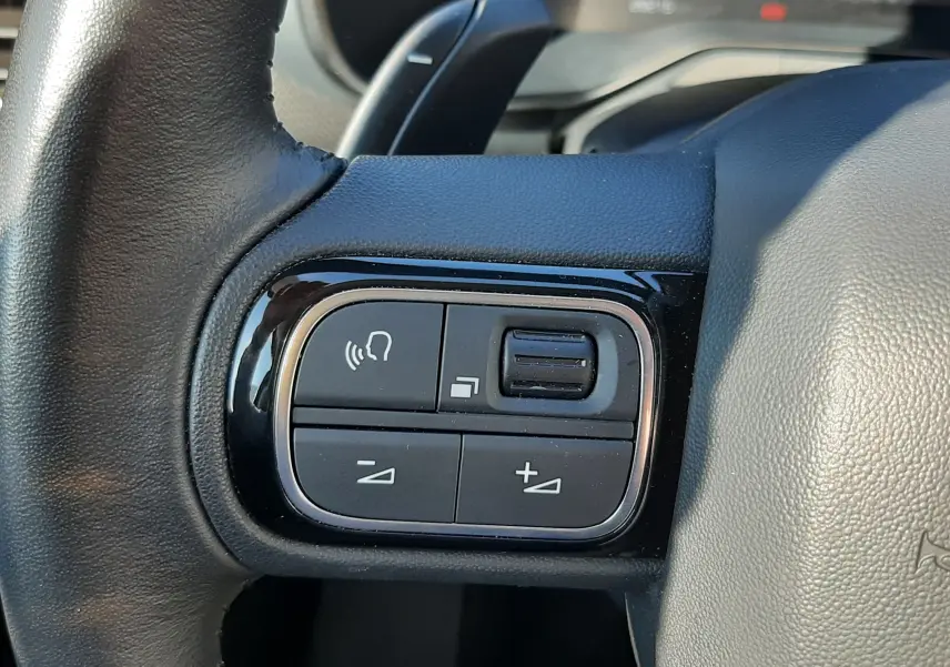 Gros plan sur les commandes multifonctions à gauche du volant du Citroën C5 Aircross 2024 noir Perla Nera.