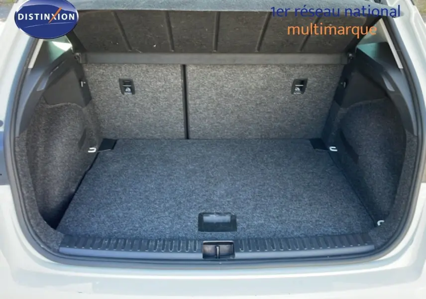 Coffre ouvert vu de l'arrière d'un SEAT Arona blanc avec toit gris, montrant l'espace de chargement vide et tapissé.
