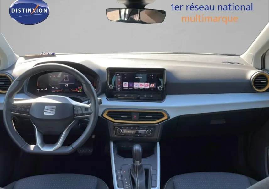 Vue intérieure avant du SEAT Arona 2025, tableau de bord noir avec écran tactile et volant multifonction cuir.