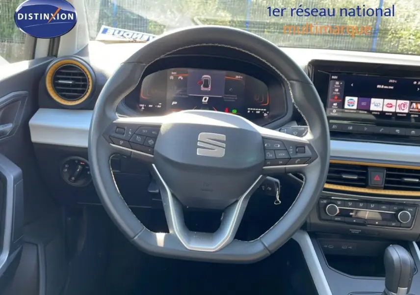 Vue centrée sur le volant cuir de la SEAT Arona 2025 avec tableau de bord digital et écran tactile couleur.