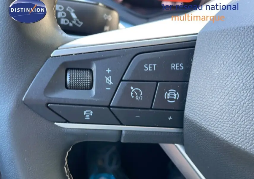 Gros plan sur les commandes de régulateur de vitesse au volant d’un SEAT Arona blanc toit gris, version 2025.