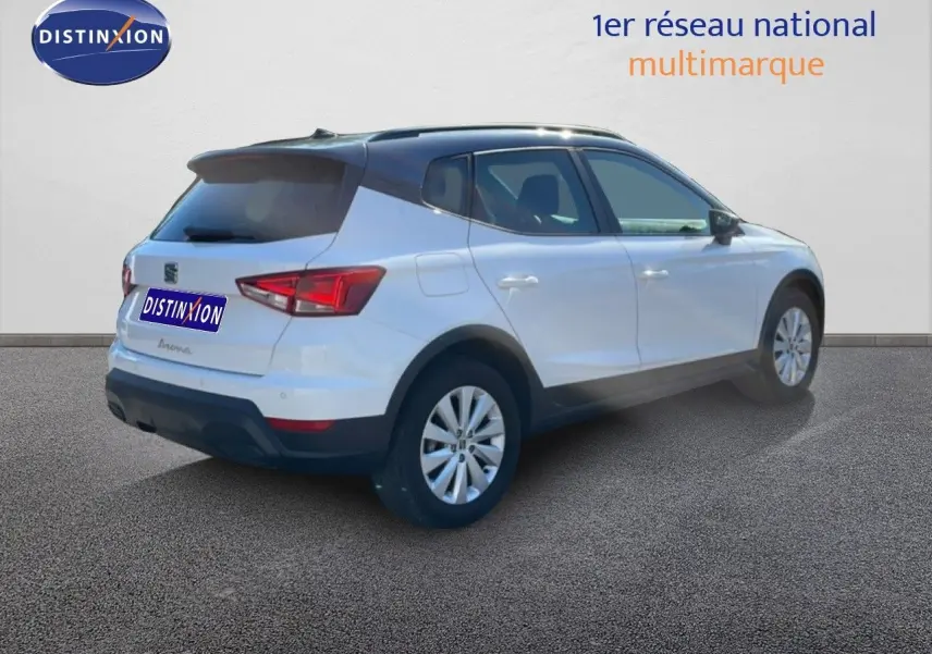 Vue 3/4 arrière droite d'un SEAT Arona blanc avec toit gris, finition Style Special Edition 2025, sur fond neutre.