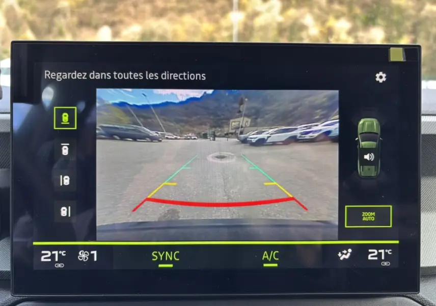 Écran multimédia montrant la caméra multiview en marche arrière du Dacia Bigster bleu indigo avec toit noir.